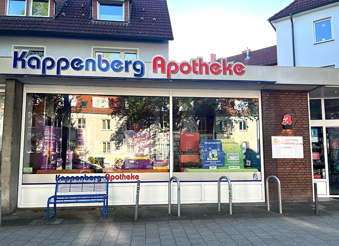 Aussenansicht der Kappenberg Apotheke, Schaufenster mit blauer Bank und Fahrradständern davor